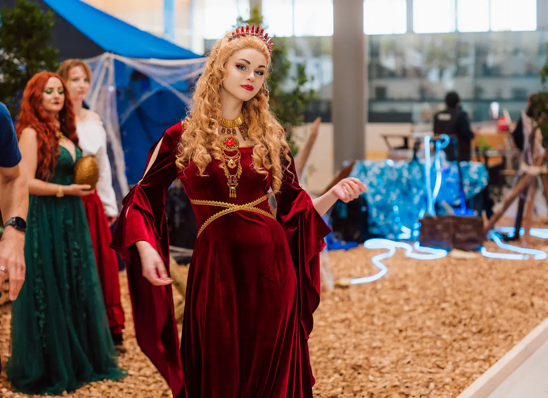 Eine Cosplayerin mit rotem Fantasy-Mittelalter-Kleid in der Messehalle vom HeroFest.