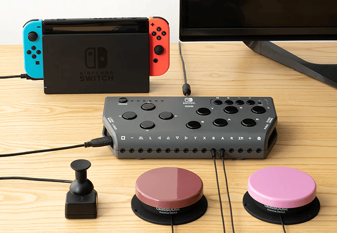 Hori Flex adaptiver Gaming-Controller mit angehängten Knöpfen. Im Hintergrund eine Nintendo Switch 2 und ein Bildschirm.